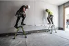 Two construction workers are using a telescoping plank on sawhorses in a room under construction. Produktbild-Vorschau