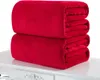 Two folded red blankets are stacked on top of each other on a white surface. Produktbild-Vorschau