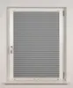 A close-up, front-facing view of a gray pleated blind installed in a white window frame. Produktbild-Vorschau