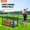 A boy holding a ball next to a ball cart on a sports field. Anteprima dell’immagine prodotto