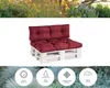 A pallet sofa with burgundy cushions on a white background, with a blurred garden scene above and icons below. Voir les images du produit