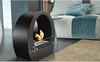 A modern black bioethanol fireplace with a flame is placed on the floor next to a sofa and a rug. Náhled obrázku produktu