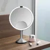 A makeup mirror and cosmetic products are displayed on a wooden surface. Náhled obrázku produktu
