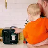 A person is holding a baby and interacting with a baby bottle warmer on a kitchen counter. Podgląd zdjęcia produktu