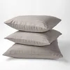 Three beige striped pillows are stacked on top of each other against a white background. Podgląd zdjęcia produktu