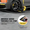 A car tire is shown pressing down on a black and yellow garage threshold seal strip. Voir les images du produit