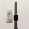A smartwatch and its accessories are laid out on a white surface. Podgląd zdjęcia produktu