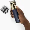 A hand holding a hair clipper with an attachment next to it. Produktbild-Vorschau