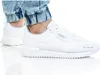 A person wearing white Puma sneakers and blue jeans. Anteprima dell’immagine prodotto