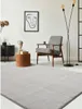 A modern living room with a rug, chair, side table, and artwork. Produktbild-Vorschau