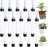A collection of plant watering indicators arranged in rows, with a diagram showing how they work and two potted plants in the background. Produktbild-Vorschau