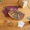 A wooden Tock board game with colorful playing pieces and a deck of cards laid out on a wooden surface. Náhled obrázku produktu