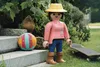 A Playmobil figure dressed as a gardener stands next to a ball and a skateboard on grass. Podgląd zdjęcia produktu