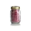 A Kilner jar with a gold lid and a red and white checkered cloth underneath. A red label with text and graphics is inside the jar. Voir les images du produit
