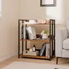 A 3-tier shelf unit with books and decorative items, placed next to a sofa in a room. Podgląd zdjęcia produktu