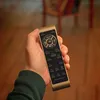 A hand holding a remote control in a room. Produktbild-Vorschau