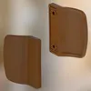 Two brown plastic door handles are shown against a light gray background. Anteprima dell’immagine prodotto