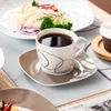 A table setting with a cup of coffee and a plate of food. Náhled obrázku produktu