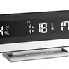 A digital alarm clock with a black display and silver base. Podgląd zdjęcia produktu