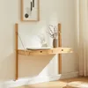 A wall-mounted wooden desk with a laptop and a vase of dried flowers. Voir les images du produit