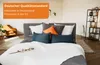 A bedroom scene with a bed made up with white bedding and several pillows. Produktbild-Vorschau