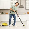 A man is cleaning the floor in a kitchen with a steam cleaner. Produktbild-Vorschau