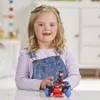 A young girl with Down syndrome is playing with a toy robot on a table. Anteprima dell’immagine prodotto