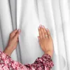 Hands touching a white curtain. Produktbild-Vorschau