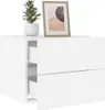 A white wall-mounted nightstand with two drawers, a potted plant, and a framed picture on top. Náhled obrázku produktu