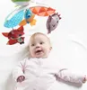 A baby looking up at a mobile with colorful toys. Voir les images du produit