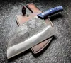 A cleaver knife with a blue handle rests on its brown leather sheath, set against a dark, textured surface. Anteprima dell’immagine prodotto