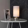 A table lamp and a framed photo are placed on a small table. Produktbild-Vorschau