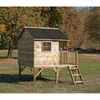 A wooden playhouse on stilts in an outdoor setting with trees and grass. Produktbild-Vorschau