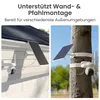 The image shows two different mounting options for a solar-powered security camera system: one mounted on a white wall and another on a tree trunk. Produktbild-Vorschau