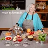 A woman in a kitchen, with a food preparation appliance and ingredients on the counter. Produktbild-Vorschau