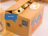 A coin bank shaped like a cardboard box with a cat peeking out. Náhľad obrázku produktu