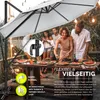 People enjoying a meal outdoors under a large umbrella. Produktbild-Vorschau
