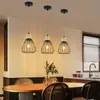 A dining area with a table and chairs, illuminated by three pendant lights. Anteprima dell’immagine prodotto