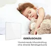 A child sleeping peacefully with a teddy bear, with a white heating panel in the foreground. Produktbild-Vorschau