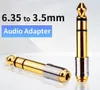 Two audio adapters are shown against a light, abstract background. One adapter is lying down in the foreground, and the other is standing upright in the background. Anteprima dell’immagine prodotto