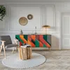 A modern living room with a colorful sideboard, a chair, a round rug, and a wooden side table. Anteprima dell’immagine prodotto