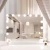 A well-lit vanity mirror with lights, reflecting a modern interior with a kitchen and dining area. Produktbild-Vorschau