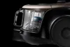 A close-up, studio shot of a vacuum cleaner's dustbin and part of its body against a black background. Náhled obrázku produktu