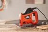 A Black & Decker electric reciprocating saw is placed on a wooden surface with a cutting mat underneath. Podgląd zdjęcia produktu