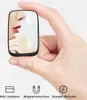A hand is holding a small black rectangular object with a mirrored surface that reflects a person's face and digital battery indicators. Below the object are three icons with German text labels. Produktbild-Vorschau