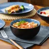 A close-up view of a table setting with bowls of food and a plate of salmon. Voir les images du produit