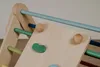 A close-up view of a wooden climbing triangle for children, with colorful rungs and climbing holds. Produktbild-Vorschau