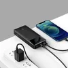 A black power bank is charging a smartphone, while also being charged by a wall adapter. Podgląd zdjęcia produktu