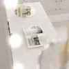A vanity table with a magazine and decorative items. Produktbild-Vorschau