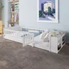 A white children's bed with a guardrail and attached shelving unit, set in a bedroom with a light blue wall and a grey carpet. Produktbild-Vorschau
